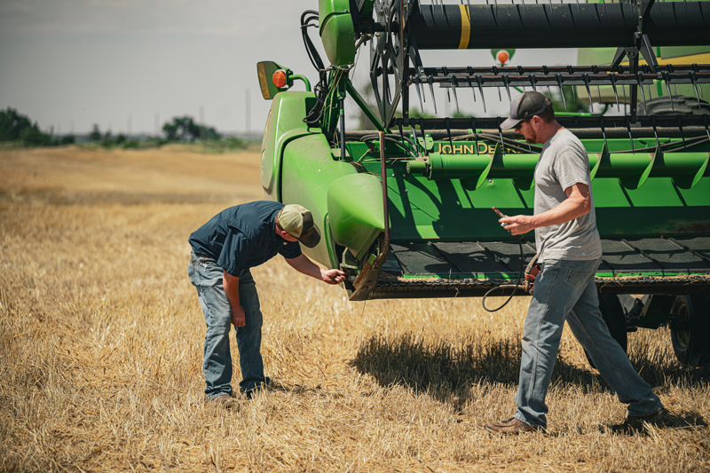 Two men fixing combine - home