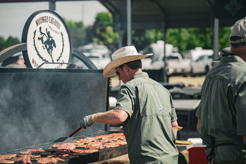 man grilling burgers and woodward elks rodeo